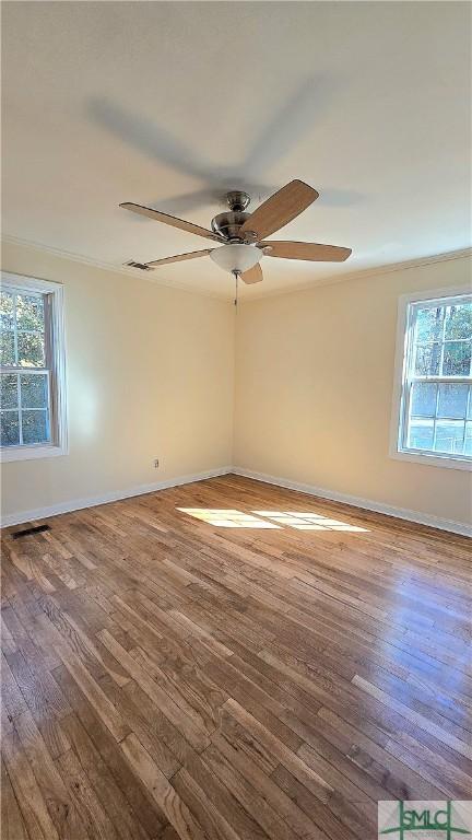 unfurnished room with plenty of natural light, a ceiling fan, and wood finished floors