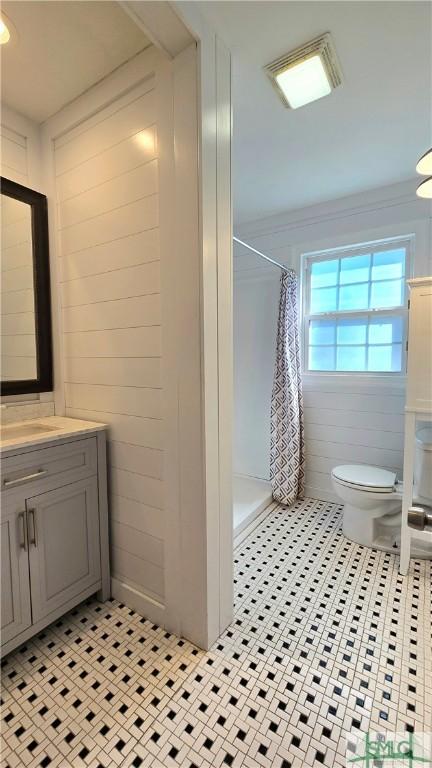 full bathroom with curtained shower, ornamental molding, toilet, vanity, and tile patterned flooring