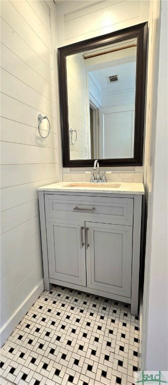 bathroom with wood walls, vanity, and visible vents