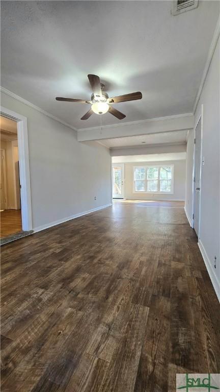 empty room featuring baseboards, dark wood-style floors, crown molding, visible vents, and ceiling fan