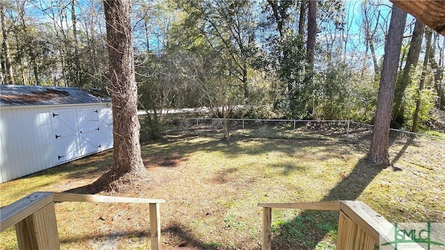 view of yard with an outbuilding, a fenced backyard, and a storage unit