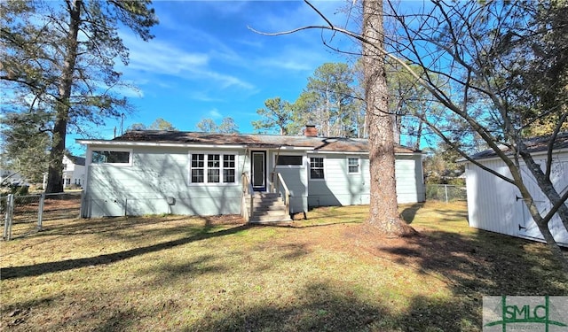 rear view of property featuring a lawn