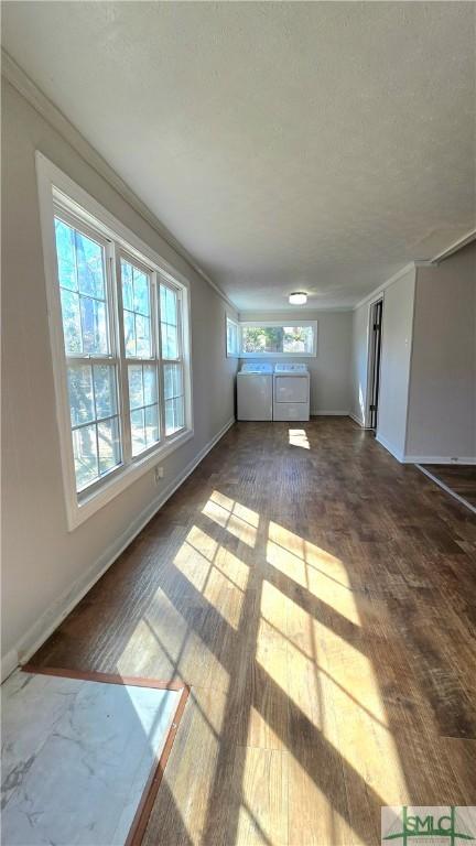 unfurnished living room with wood finished floors and baseboards