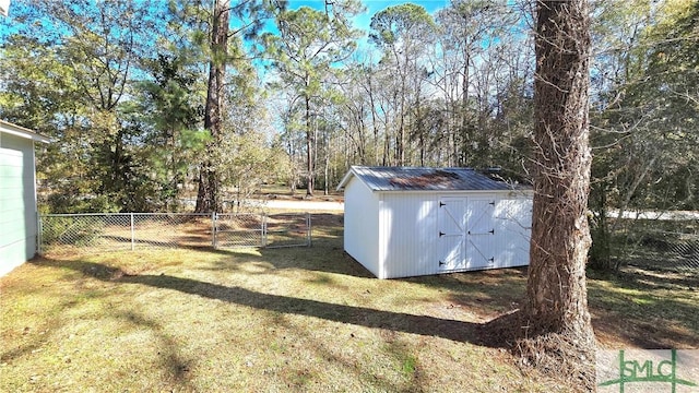 view of yard featuring an outbuilding, a shed, and fence
