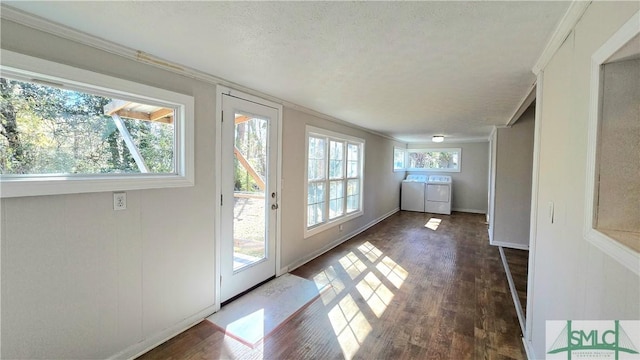 doorway to outside with ornamental molding, separate washer and dryer, dark hardwood / wood-style floors, and a textured ceiling