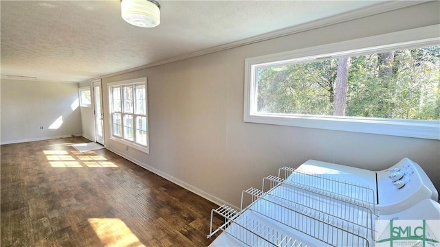 interior space with a textured ceiling, baseboards, and wood finished floors