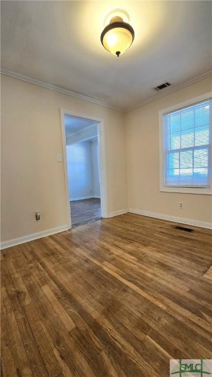 spare room with crown molding and hardwood / wood-style floors