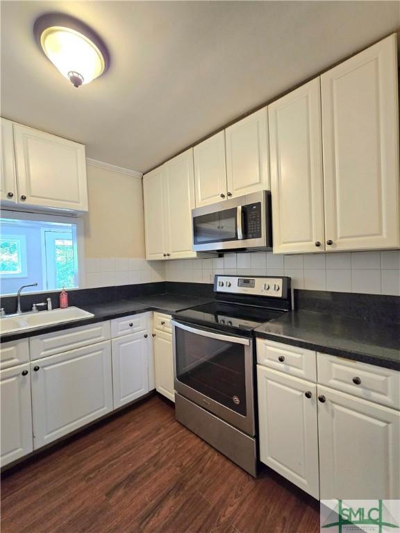 kitchen with a sink, white cabinetry, and stainless steel appliances