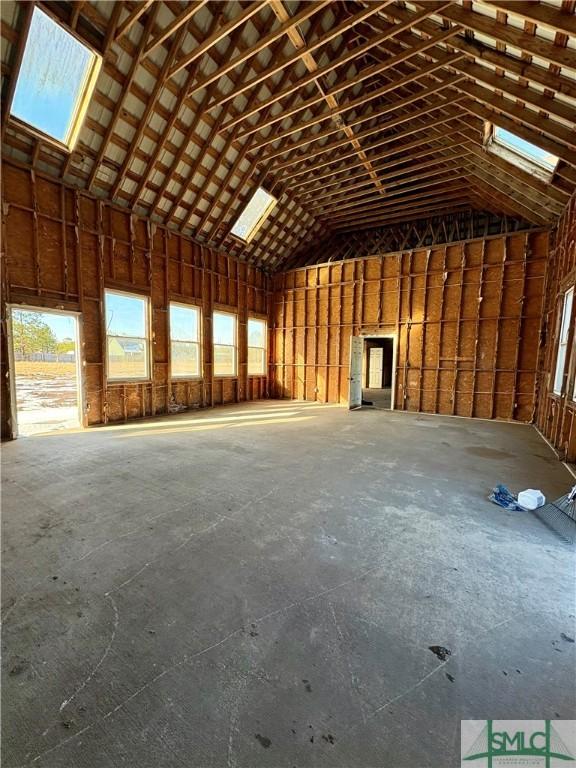 miscellaneous room featuring concrete floors and high vaulted ceiling