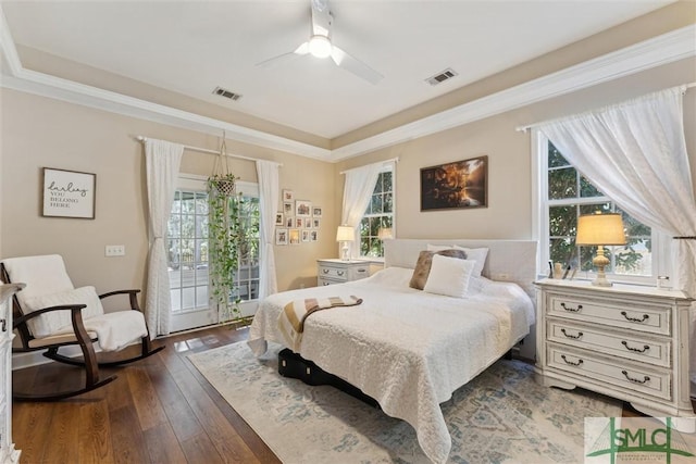 bedroom with ornamental molding, dark hardwood / wood-style flooring, and multiple windows