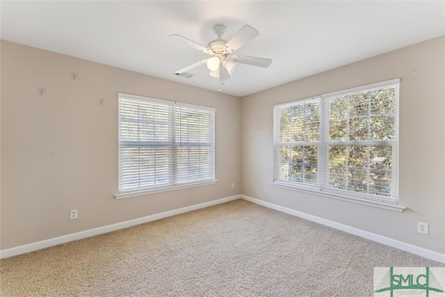 carpeted spare room with plenty of natural light and ceiling fan