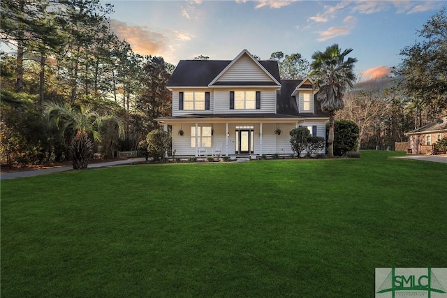 view of front of house with covered porch and a lawn