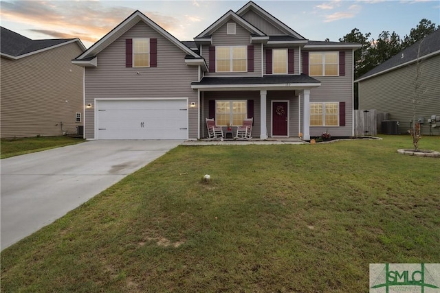 view of front facade with a garage, a porch, a yard, and central AC