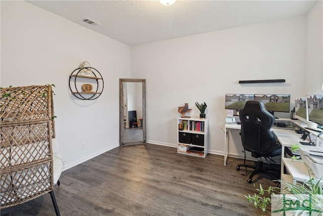 home office with dark wood-type flooring and a textured ceiling