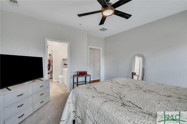 bedroom with arched walkways, light carpet, visible vents, and baseboards