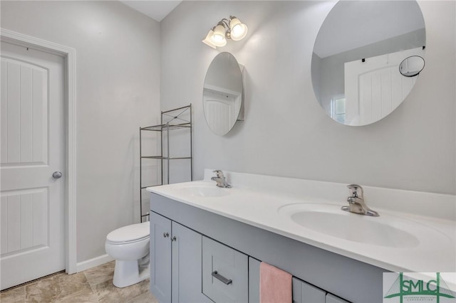 full bathroom featuring double vanity, a sink, and toilet