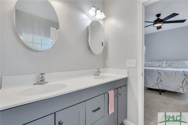 ensuite bathroom featuring ceiling fan, connected bathroom, a sink, and double vanity