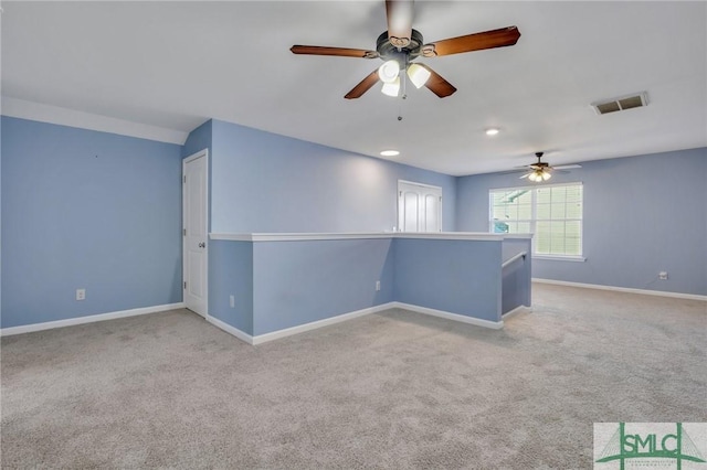 spare room featuring visible vents, ceiling fan, light carpet, and baseboards