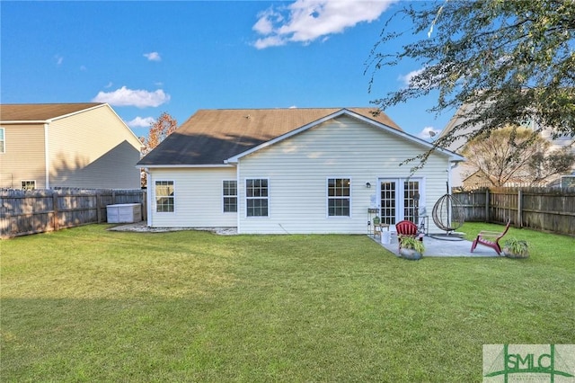 rear view of house featuring a fenced backyard, a patio, and a lawn