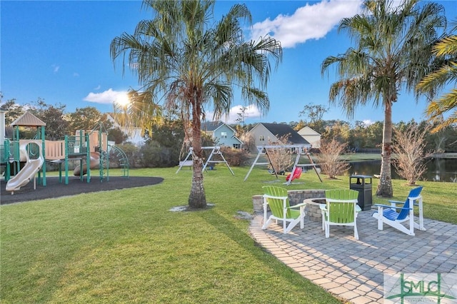 view of yard featuring a patio area, playground community, and a water view