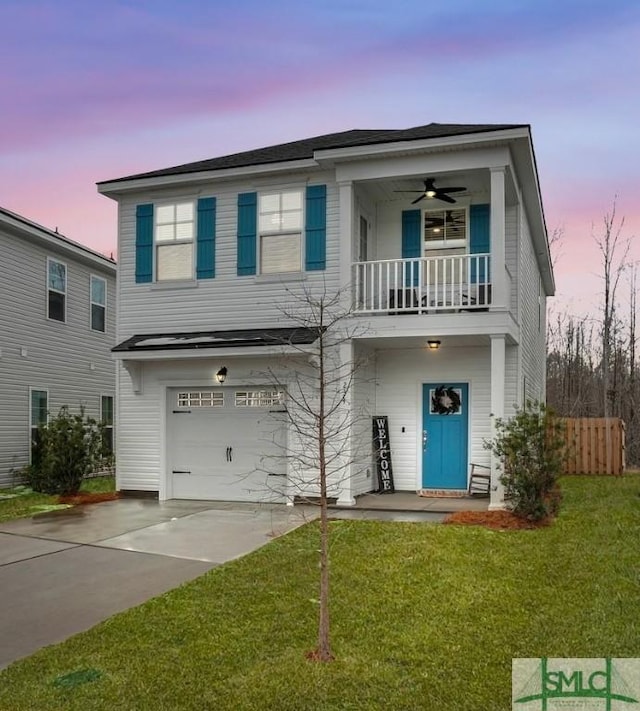 view of front of home featuring ceiling fan, a balcony, a garage, and a yard