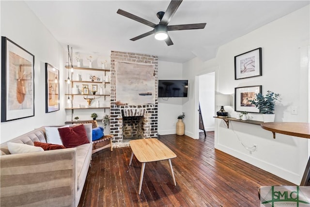 living room featuring a brick fireplace, dark hardwood / wood-style floors, and ceiling fan