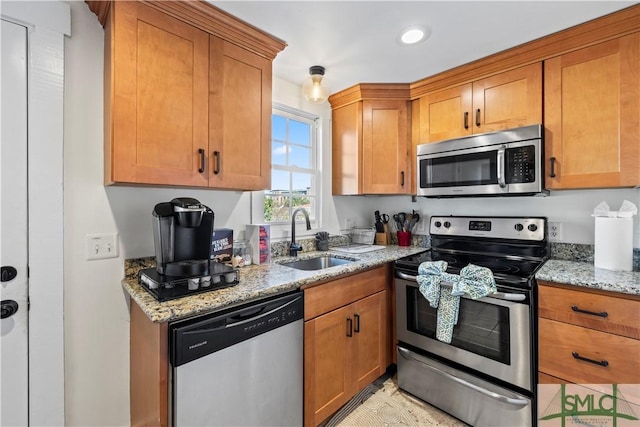 kitchen with sink, stainless steel appliances, and light stone countertops