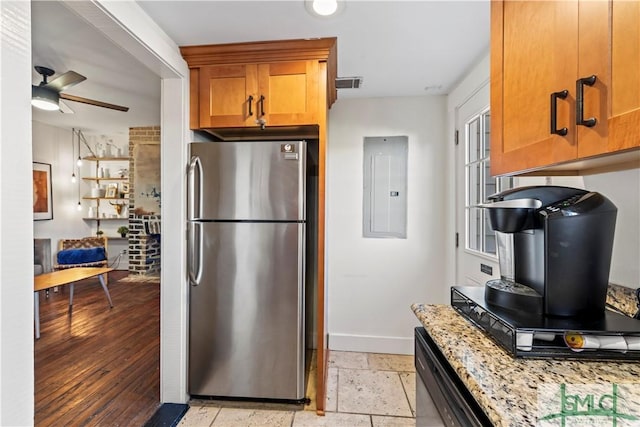 kitchen featuring light stone counters, stainless steel refrigerator, dishwasher, electric panel, and ceiling fan