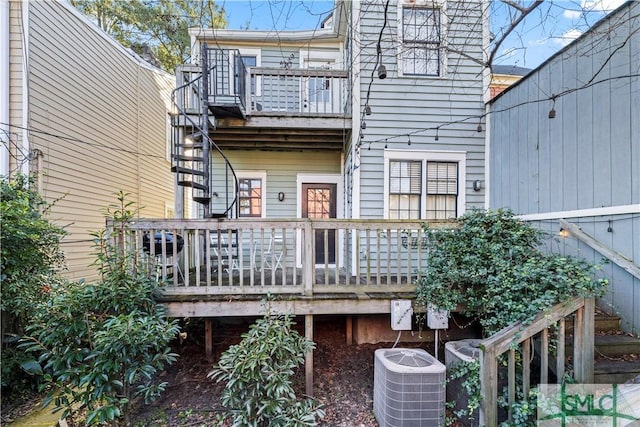 rear view of house with central AC and a deck