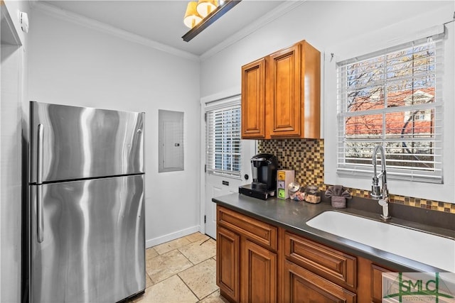 kitchen featuring sink, ornamental molding, stainless steel fridge, electric panel, and backsplash