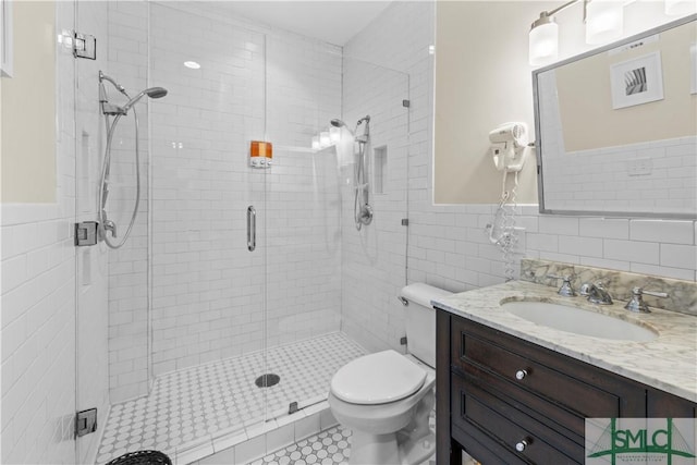 bathroom featuring tile walls, tile patterned flooring, vanity, an enclosed shower, and toilet