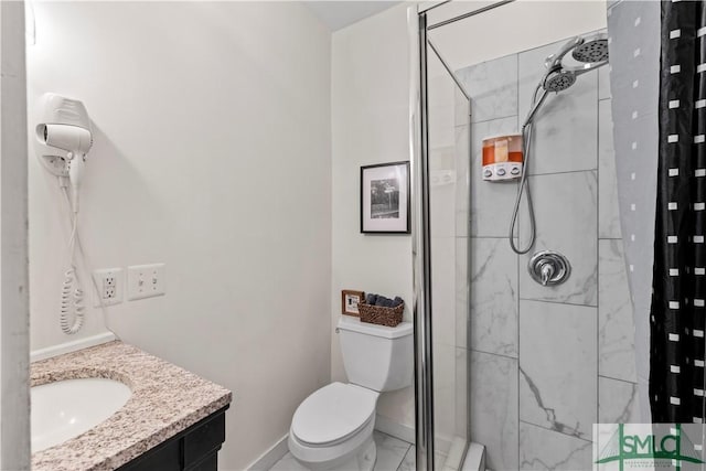 bathroom with vanity, toilet, and tiled shower