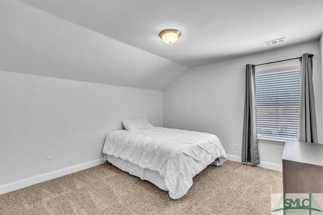 carpeted bedroom with lofted ceiling