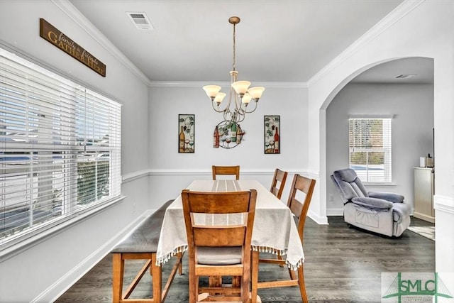 dining area with crown molding, dark hardwood / wood-style floors, and a notable chandelier