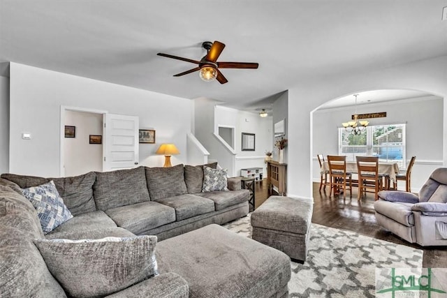 living room featuring hardwood / wood-style floors, ceiling fan with notable chandelier, and ornamental molding