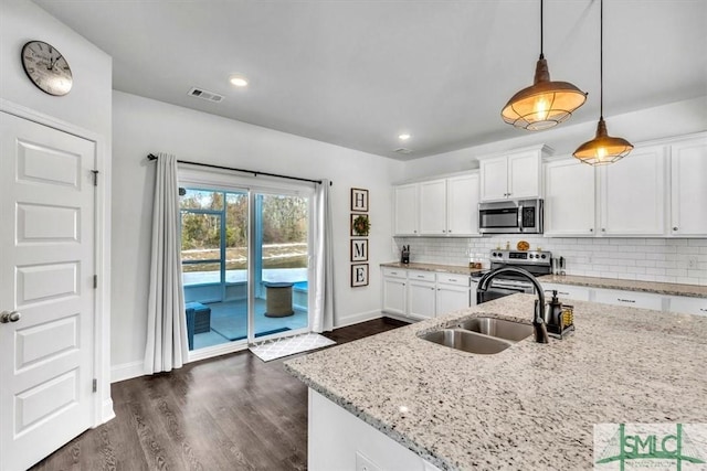 kitchen featuring pendant lighting, light stone counters, white cabinetry, and stainless steel appliances