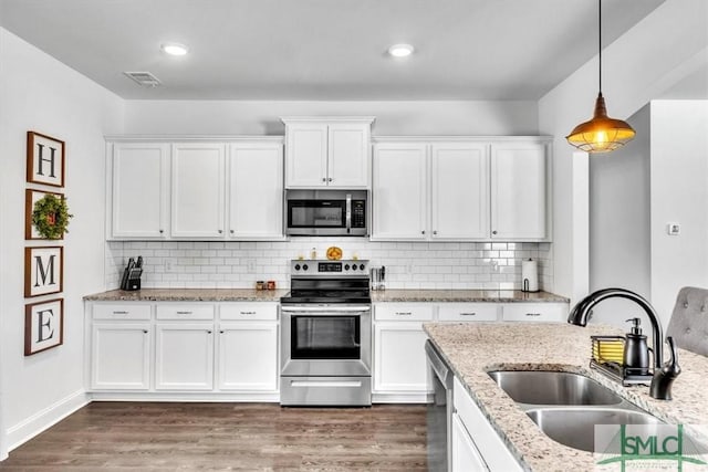 kitchen with white cabinetry, sink, stainless steel appliances, and hanging light fixtures