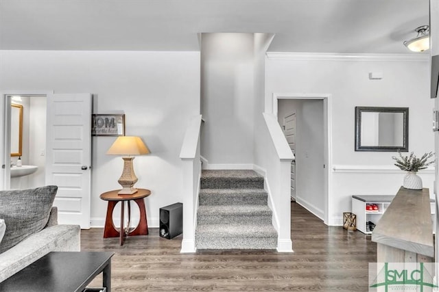 stairway featuring crown molding and hardwood / wood-style flooring