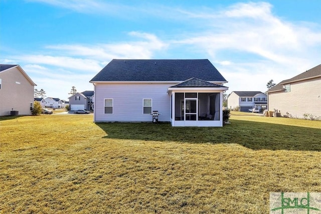 back of property featuring a sunroom and a lawn