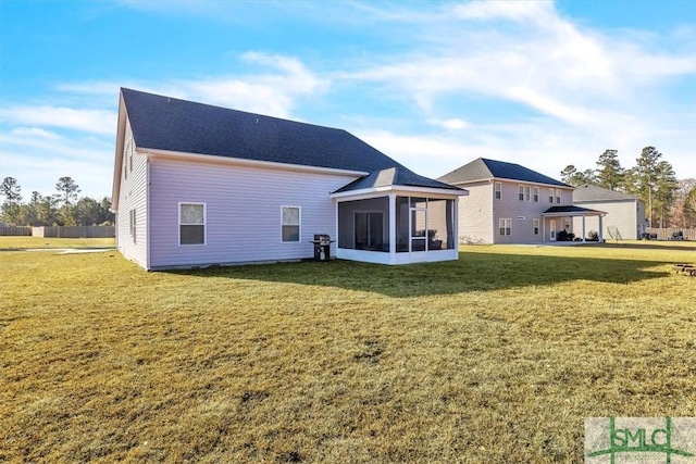 rear view of house with a gazebo, a sunroom, and a lawn