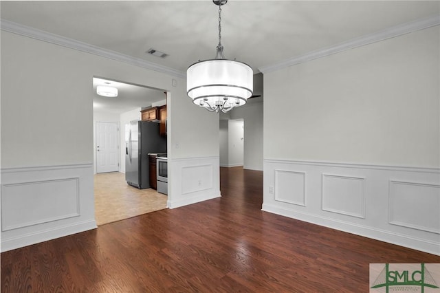 unfurnished dining area with an inviting chandelier, ornamental molding, and hardwood / wood-style floors