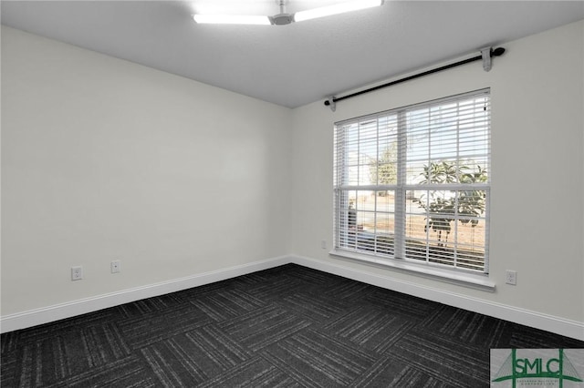 spare room featuring dark colored carpet