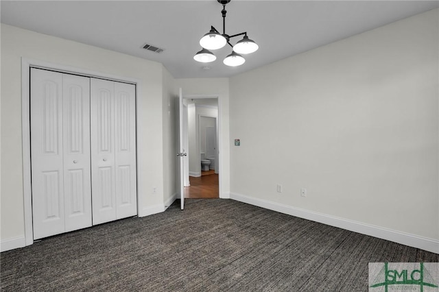 unfurnished bedroom with a closet and dark colored carpet