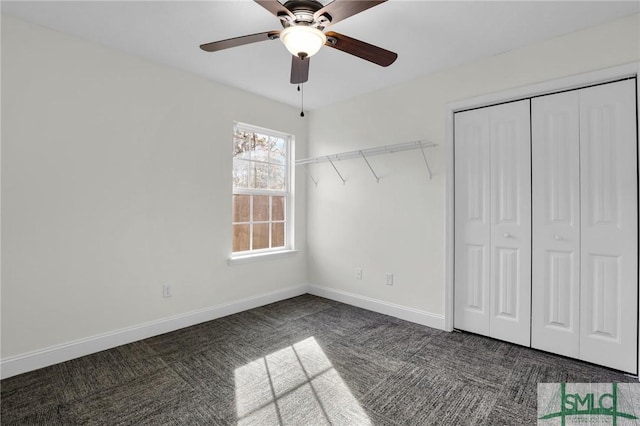 unfurnished bedroom with a closet, ceiling fan, and dark colored carpet