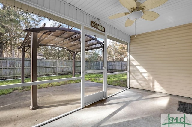 unfurnished sunroom with ceiling fan