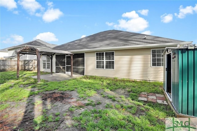 back of property with a gazebo, a patio area, a sunroom, and a lawn