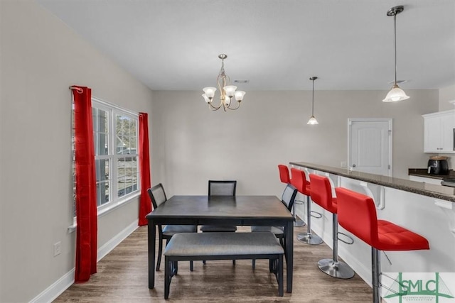 dining space featuring dark hardwood / wood-style flooring and a notable chandelier