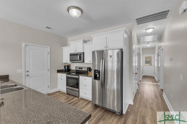 kitchen featuring white cabinetry, stainless steel appliances, sink, and wood-type flooring