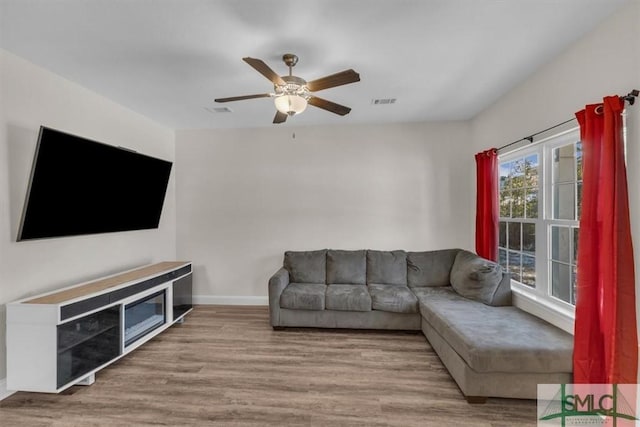 living room featuring ceiling fan and light wood-type flooring