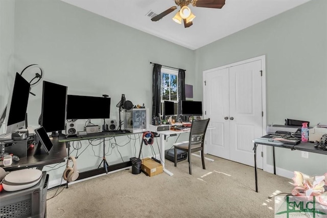 carpeted home office featuring ceiling fan